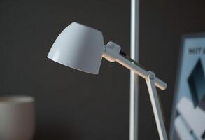 white desk lamp sitting on top of a table photo