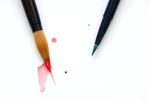 Two paint brushes with red and blue paint on them photo