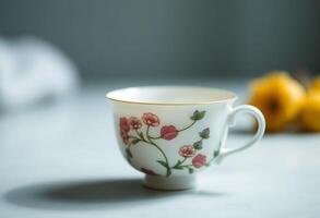 A cup with a flower design on it sits on a table photo