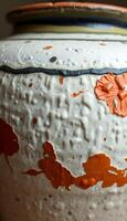 white and orange vase with a flower on it photo