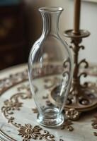 A glass vase sitting on a table next to a lamp photo