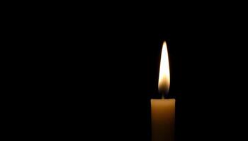 lit candle in the dark on a table photo