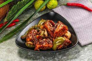 A bowl of food with meat, peppers and other vegetables photo