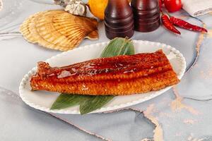 A plate of fish on a table with a bottle of ketchup photo