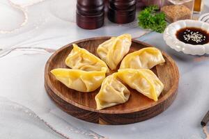 Dumplings on a wooden plate with sauce and spices photo