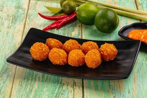 A plate of fried food with a lime and a green leaf photo