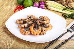 A plate of shrimp with vegetables and a fork photo