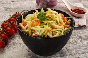 A bowl of vegetables and a spoon of sauce photo
