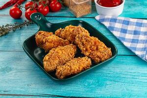 Fried chicken in a dish on a blue table photo