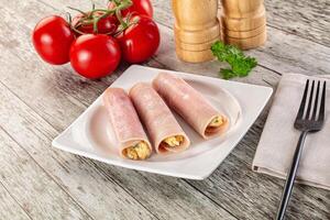 Three ham and cheese rolls on a plate with a fork and knife photo