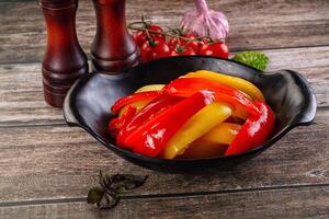 A bowl of peppers and garlic on a table photo