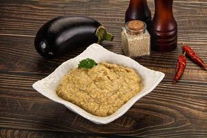 A bowl of hummus with eggplant and spices photo