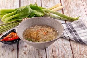A bowl of soup with vegetables on a table photo