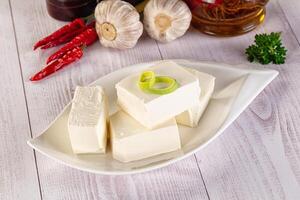 A white plate topped with cubes of tofu and garlic photo