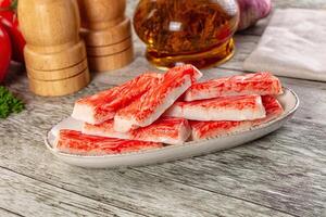A bowl of sliced meat on a table next to a bottle of ketchup photo