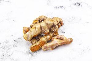 A close up of ginger root on a white surface photo