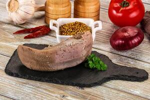 A meat on a cutting board with spices and other ingredients photo