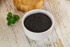 A bowl of black seed on a table photo