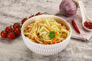 A bowl of salad with carrots, onions and tomatoes photo