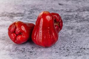 Three red apples on a gray background photo