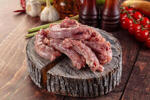 Raw meat on a wooden table with vegetables and other ingredients photo