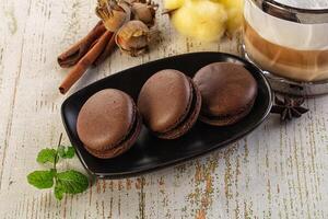 A table with a cup of coffee and three chocolate cookies photo