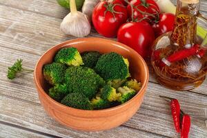 A bowl of broccoli with tomatoes, garlic, and other ingredients photo