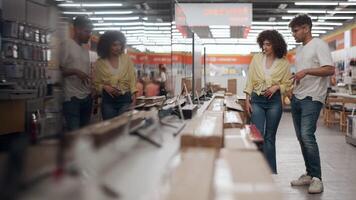 ung par bläddring tv visa, jämförande annorlunda modeller medan försäljare förklara funktioner i detaljerad långsam rörelse, highlighting modern elektronik handla erfarenhet video