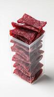 A clear plastic container filled with beef jerky photo