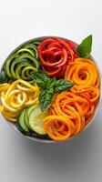 A bowl of colorful vegetables with a basil leaf photo