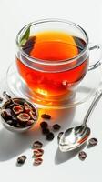 A cup of tea with a spoon and a spoon of black tea on a white background photo