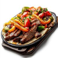 A plate of steak and vegetables on a wooden board photo