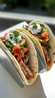 Two tacos sitting on a silver tray photo