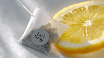 Earl Grey tea bag steeps in hot water with a citrus slice, illuminated by natural morning light photo