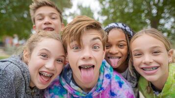 A vibrant group of kids celebrates with big smiles and silly faces while showcasing their metal braces outdoors photo