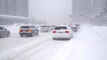 Traffic jams form as cars navigate through deep snow in a winter storm on a busy urban highway photo