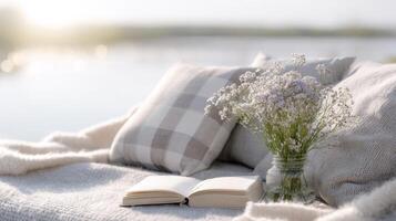 Soft pillows and a journal await by the serene lakeside, illuminated by a gentle sunset photo