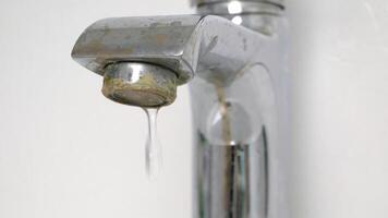 The old faucet was covered with lime scale due to poor water quality and hard water. Water is dripping from a damaged faucet. Useless use of water. Plumbing problems. video