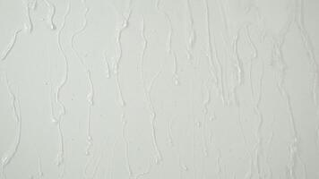 Water background with water movement, drops and splashesSmall streams of clear water flow down the white wall. Spa background with place to copy and text video