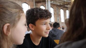 Young individuals actively participate in a modern art workshop within a restored warehouse gallery photo