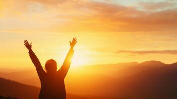 Silhouette of an individual embracing nature's beauty at sunset in the mountains, symbolizing freedom, Earth Day concept photo
