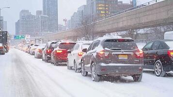Cars are stuck in traffic on a snowy day in the city, as winter weather creates difficult driving conditions photo