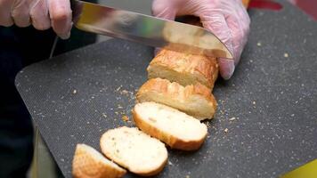 Bread slicing hands Close up shot of cutting fresh wheat bread with special knife. Preparation for breakfast or lunch. Food and drink concept video