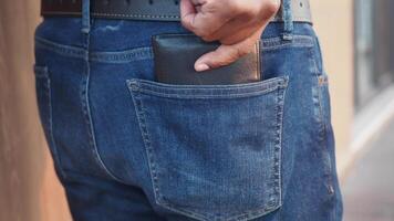 Man places hand in pocket of denim jeans in urban setting video