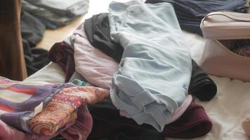 Organizing clothes on a bed to declutter bedroom space video