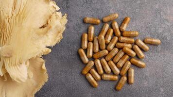 Various herbal capsules are displayed alongside dried mushrooms on a table video