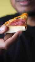 Enjoying a slice of pizza with delicious toppings video
