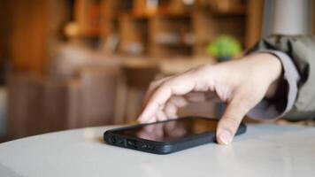 hand pick a smart phone to receive a call from a table video