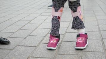 Young child walks with assistance in park setting video