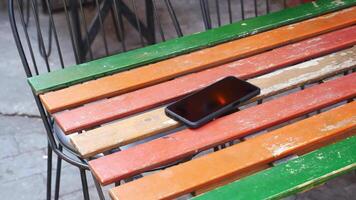 Smartphone resting on a colorful wooden table in a cafe. lost smart phone concept video